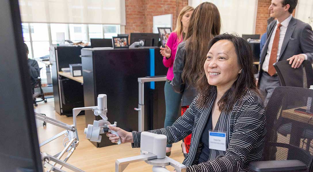 A Dallas Fed employee interacts with a robot assistant at the Texas Robotics facility at UT Austin.