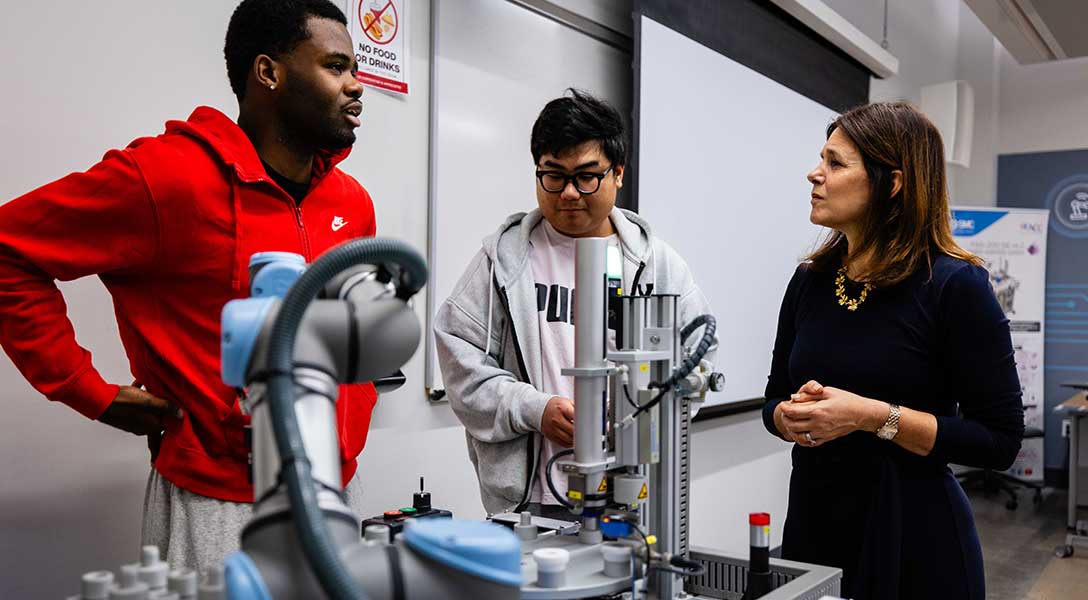 President Logan speaks with students about their experiences during a tour of Austin Community College's Innovative Manufacturing Partnerships Accelerating Central Texas (IMPACT) Lab.