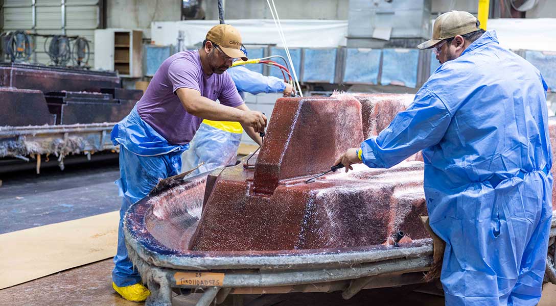 Workers craft a custom boat at the Tige Boats factory in Abilene.