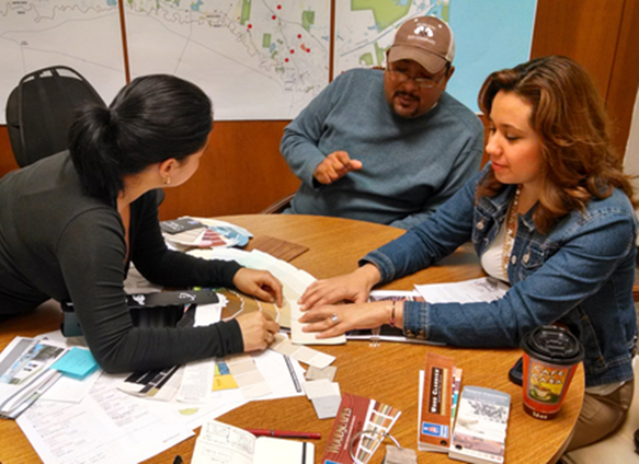 A colonia family helps in the planning of their home. Photo credit: bcWORKSHOP.